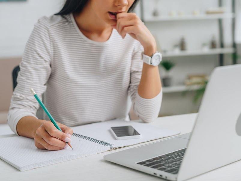 mujer-escribiendo-frente-laptop